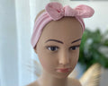 Baby Stirnband rosa mit Schleife auf Puppe getragen weiches elastisches Haarband für Babys und Kleinkinder