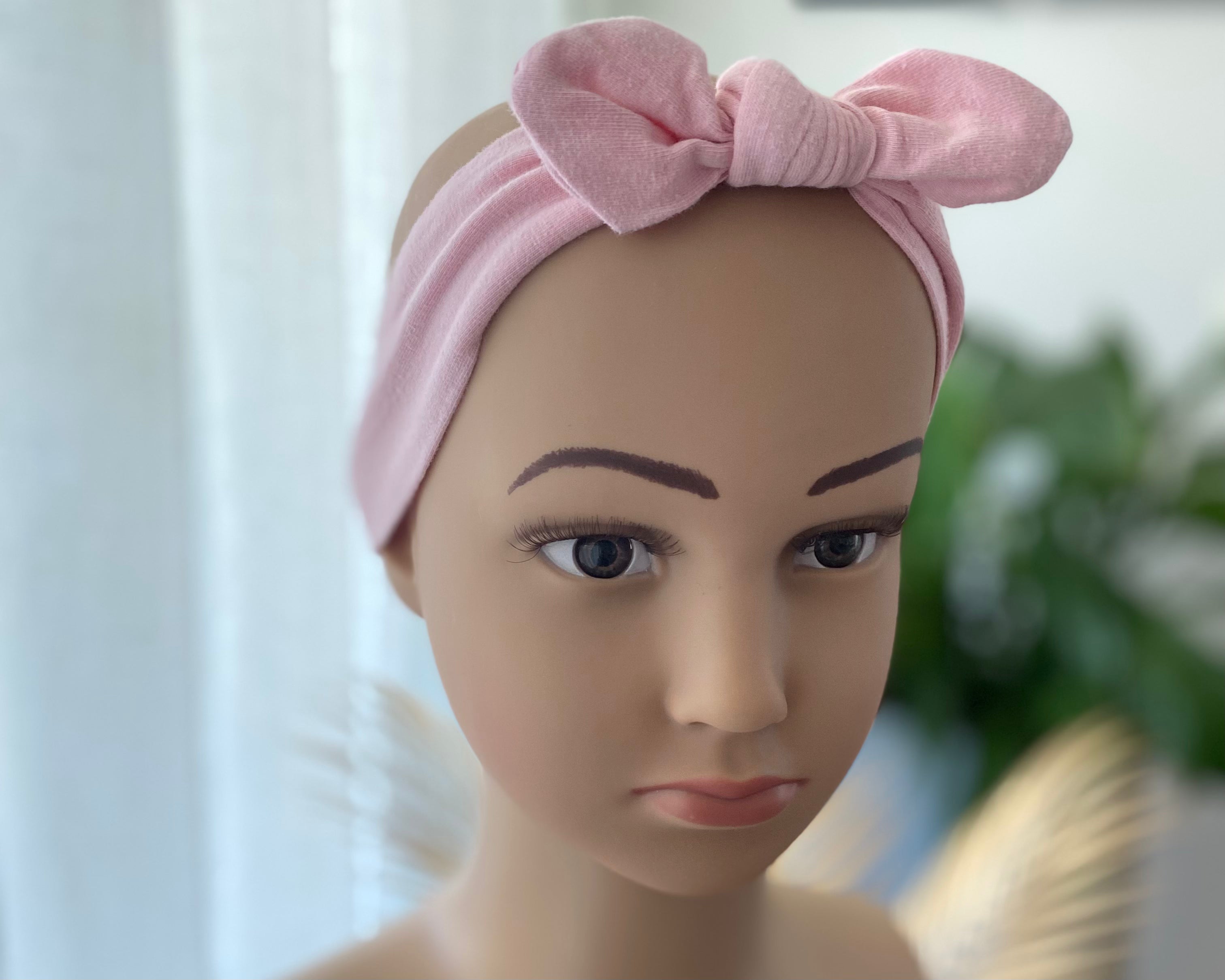 Baby Stirnband rosa mit Schleife auf Puppe getragen weiches elastisches Haarband für Babys und Kleinkinder