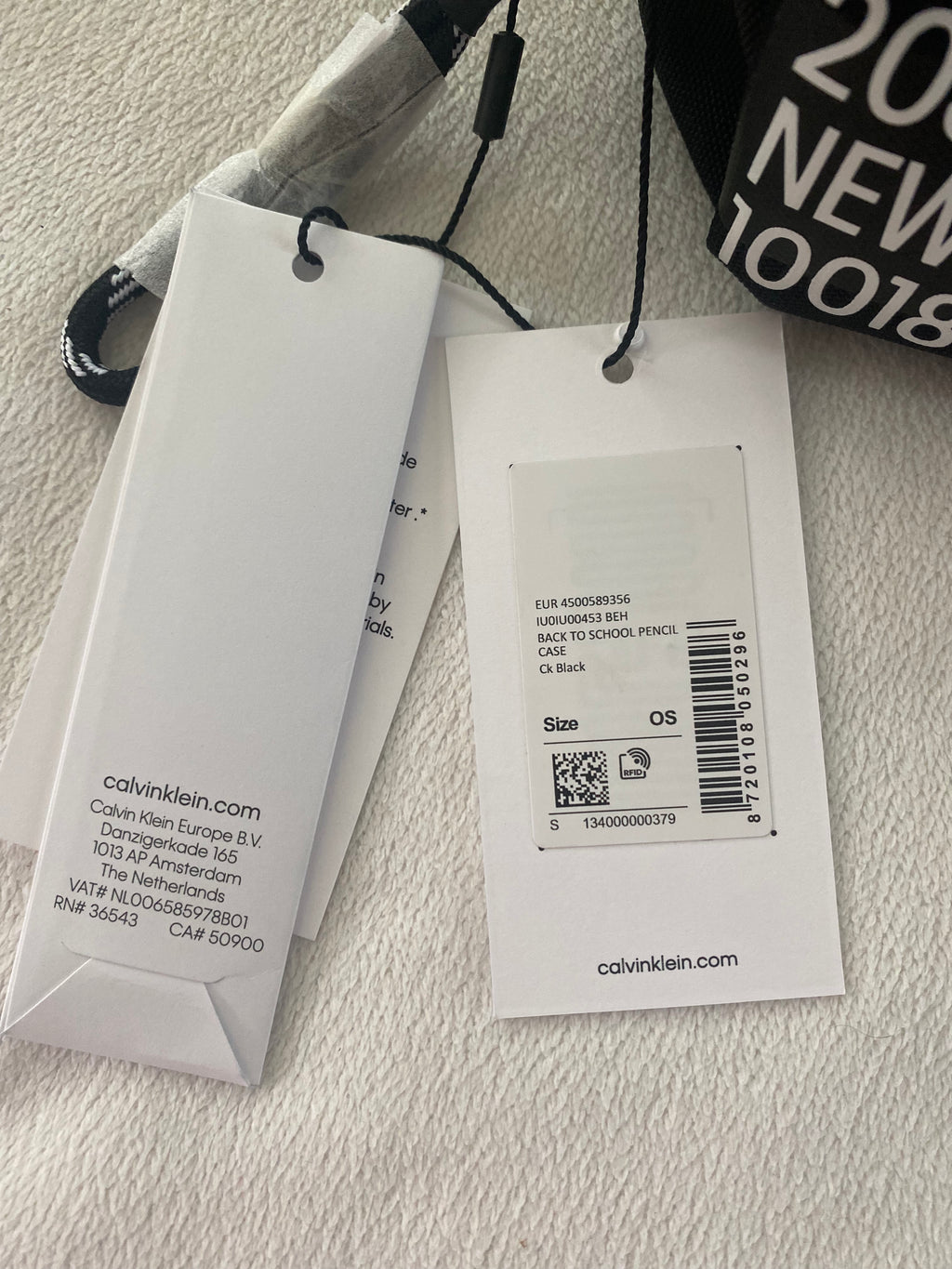 Schwarzes Calvin Klein Jeans Federmäppchen mit Reißverschluss und Originaletikett auf weißem Hintergrund. Etikett