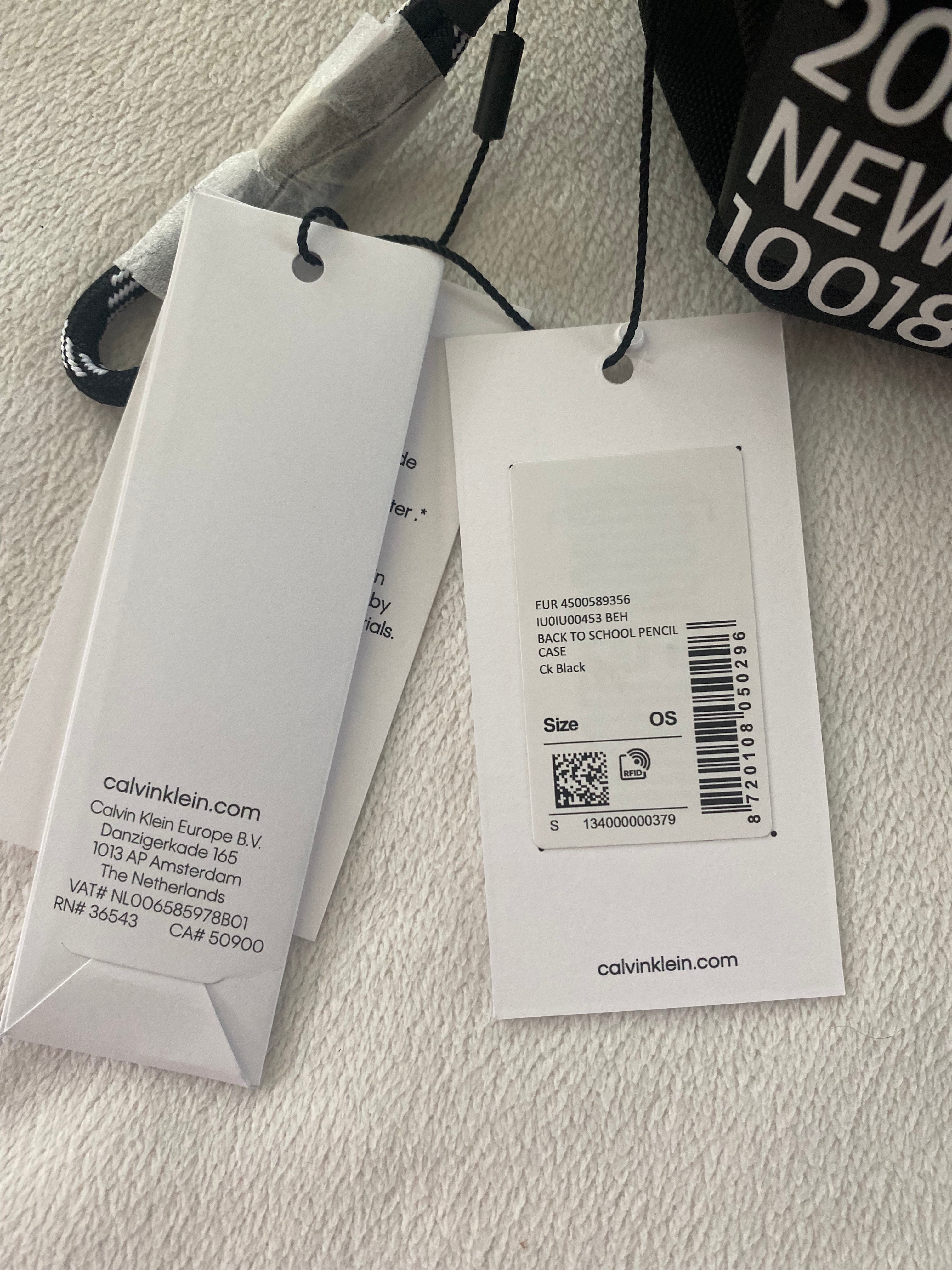 Schwarzes Calvin Klein Jeans Federmäppchen mit Reißverschluss und Originaletikett auf weißem Hintergrund. Etikett