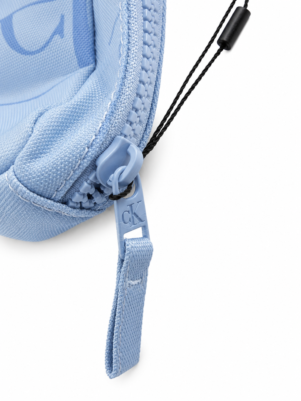 Detailaufnahme des Reißverschlusses mit CK-Logo am hellblauen Calvin Klein Jeans Federmäppchen. Hochwertige Verarbeitung und modernes Design. Verschluss