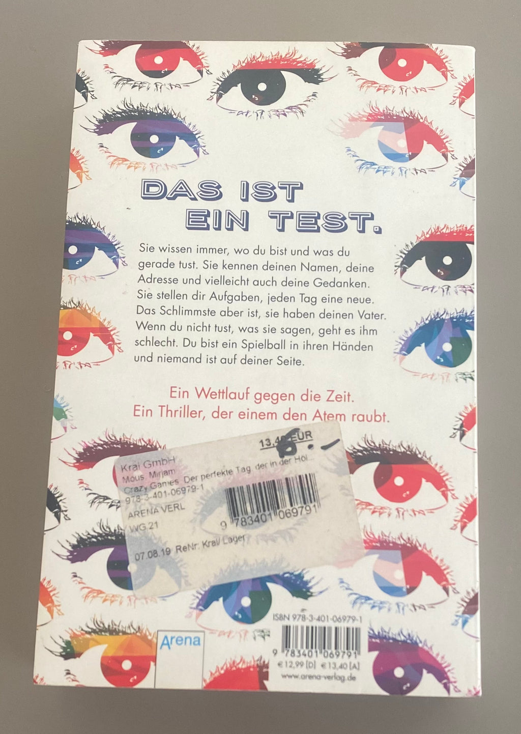 Mirjam Mous Crazy Games Jugendthriller Taschenbuch gebraucht mit buntem Augenmotiv auf weißem Cover und Arena Verlag Logo Rückansicht