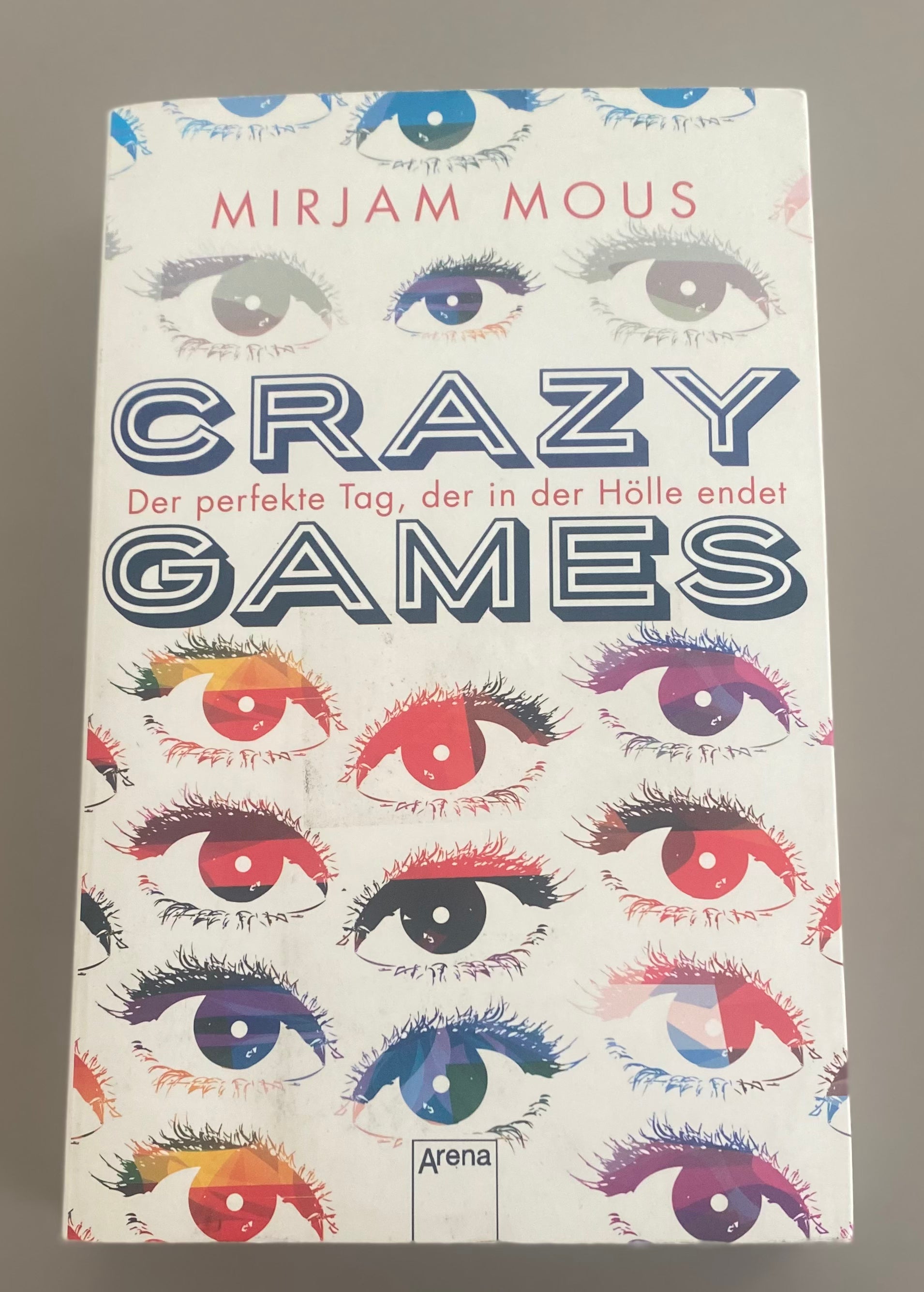 Mirjam Mous Crazy Games Jugendthriller Taschenbuch gebraucht mit buntem Augenmotiv auf weißem Cover und Arena Verlag Logo Vorderansicht