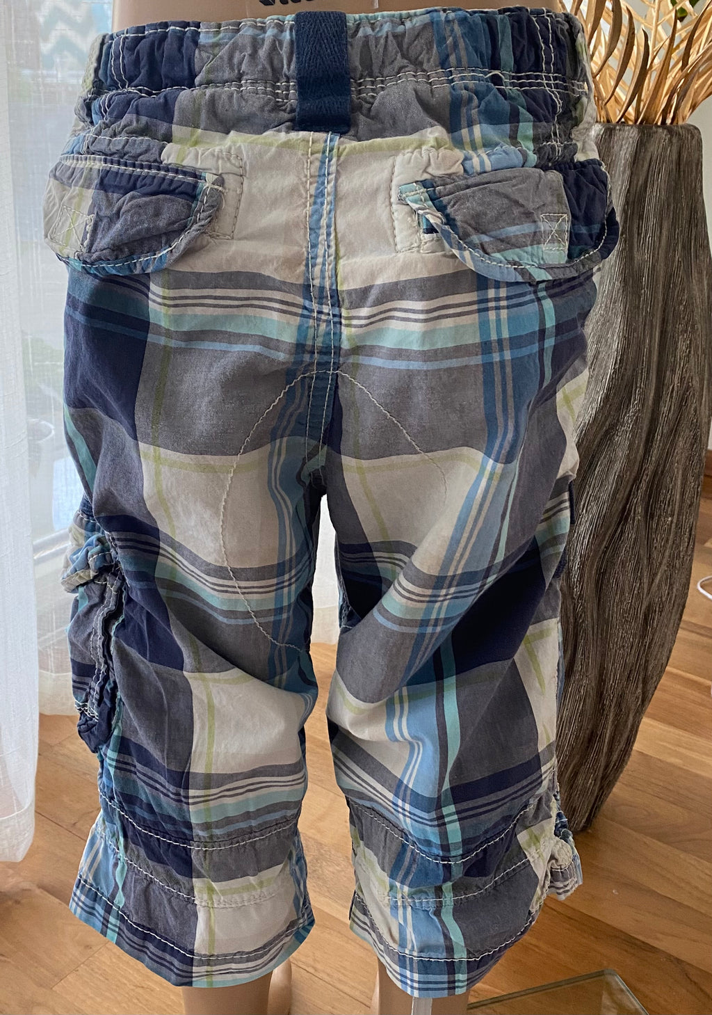 Karierte Kinder Cargo Shorts in Blau Grau mit Gesäßtaschen und elastischem Bund, Rückansicht am Mannequin