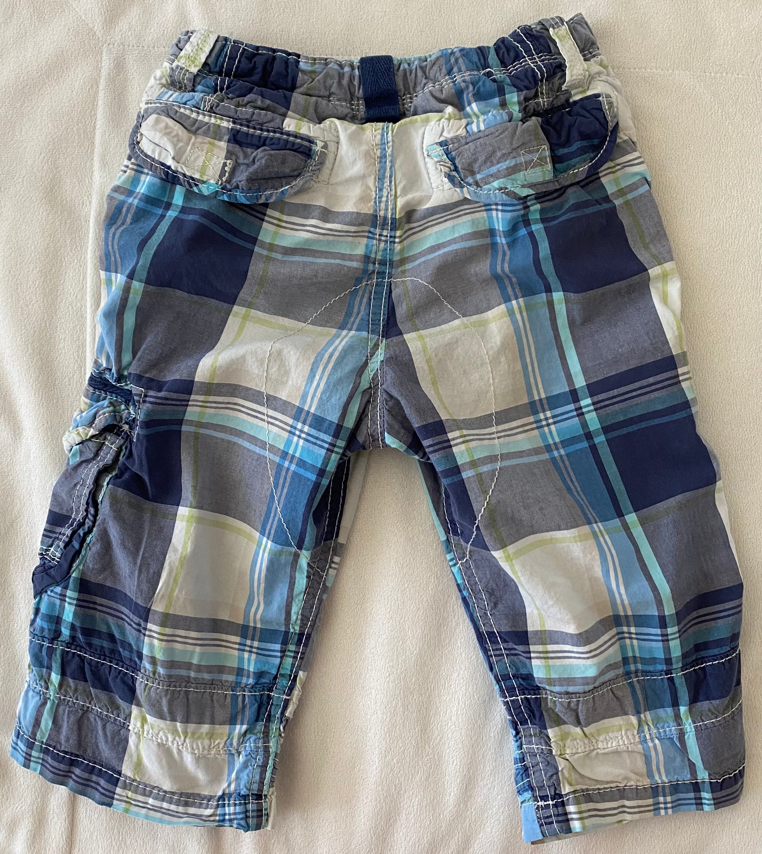 Rückansicht karierter Kinder Shorts in Blau Grau mit Gesäßtaschen, flach auf hellem Hintergrund