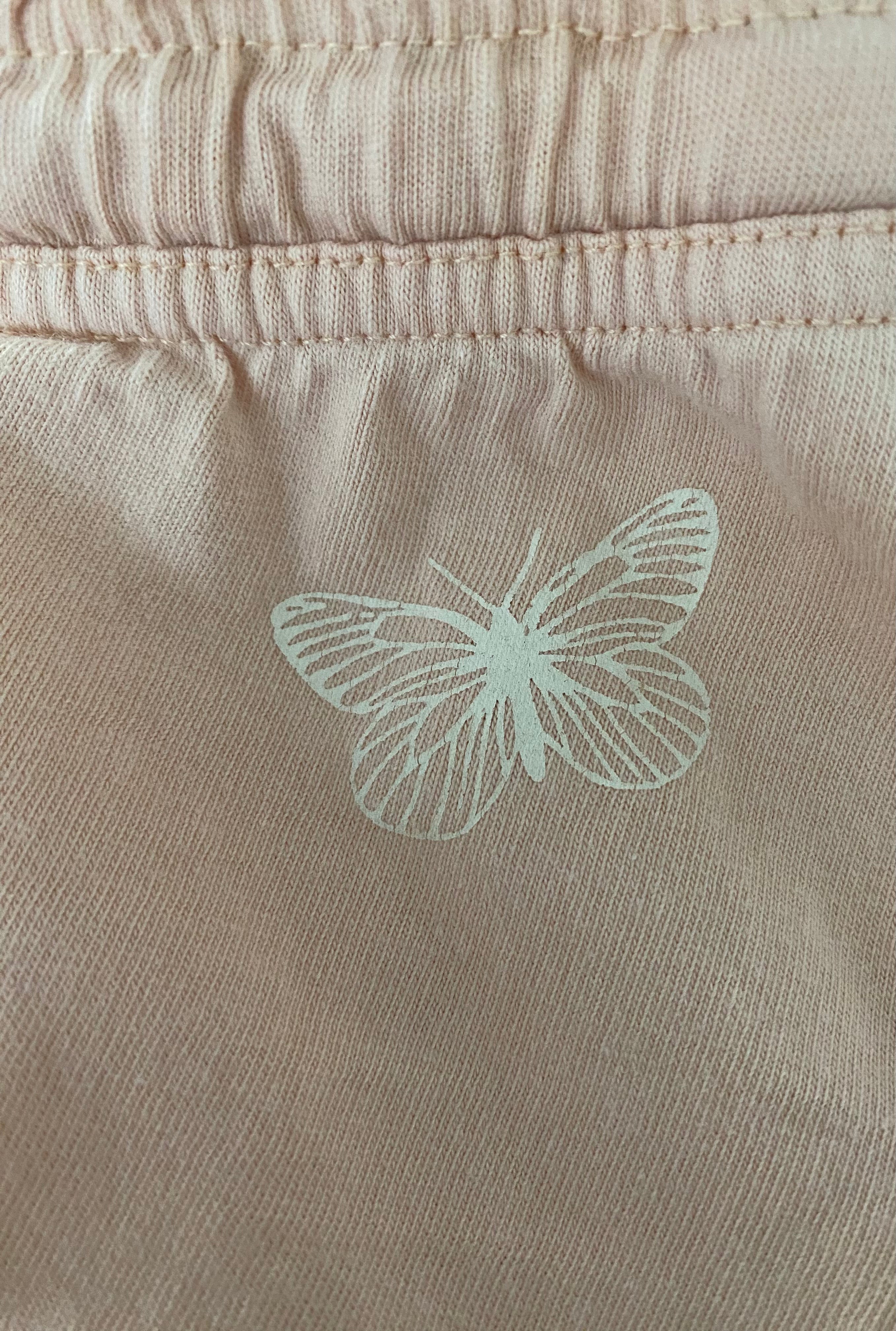 Detailaufnahme apricot Lupilu Shorts mit Schmetterling Print auf Baumwollstoff Größe 86/92