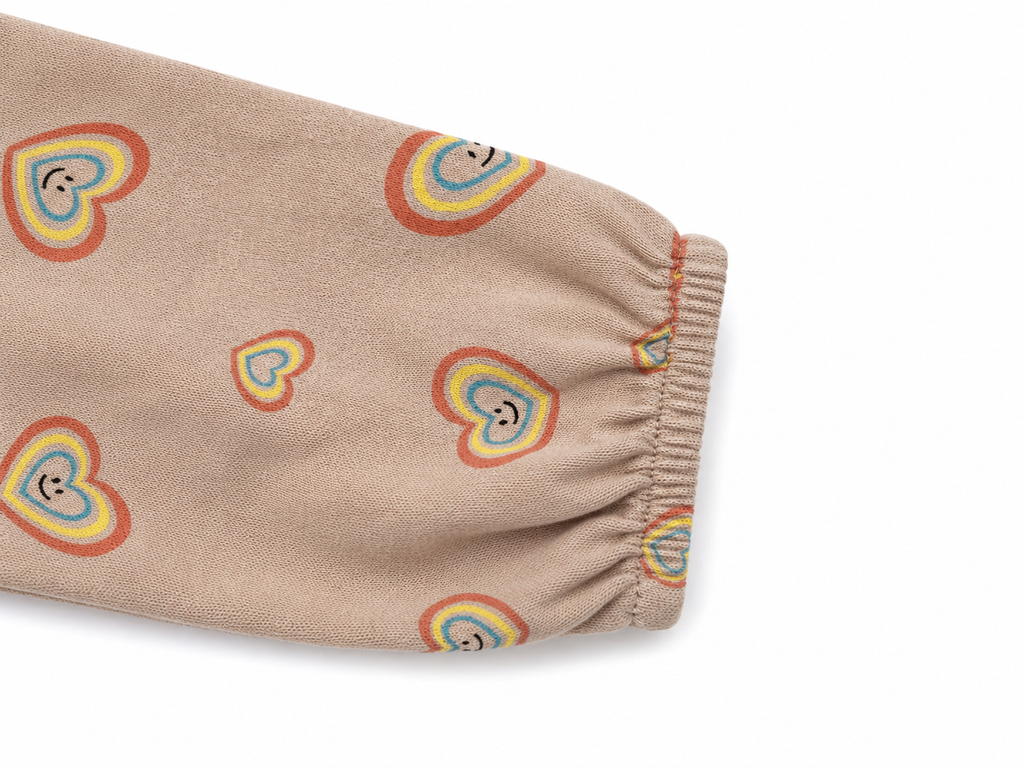 Detailaufnahme des elastischen Ärmels vom Molo Kleid in Beige mit buntem Herzmuster in Größe 92.