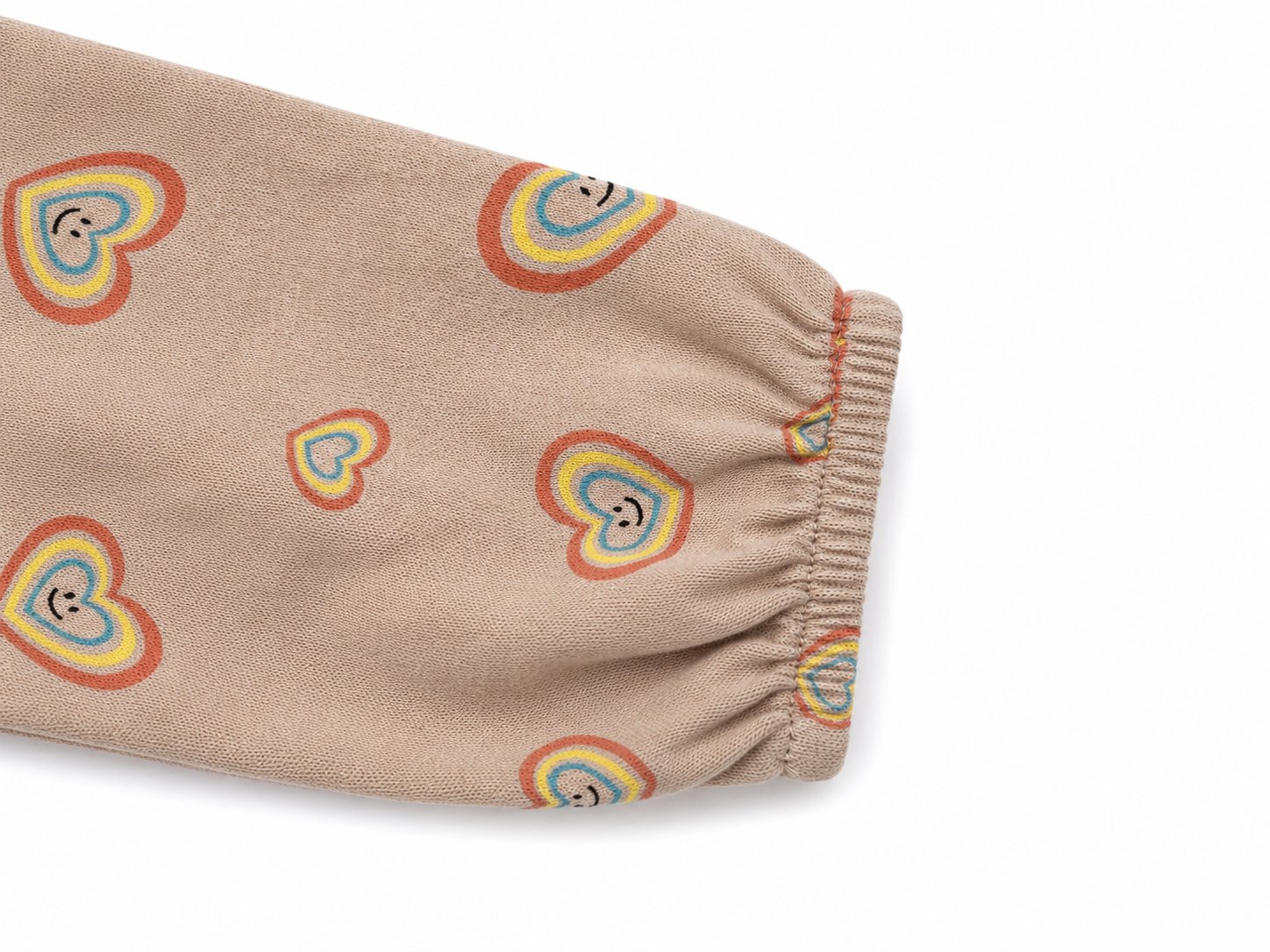 Detailaufnahme des elastischen Ärmels vom Molo Kleid in Beige mit buntem Herzmuster in Größe 92.