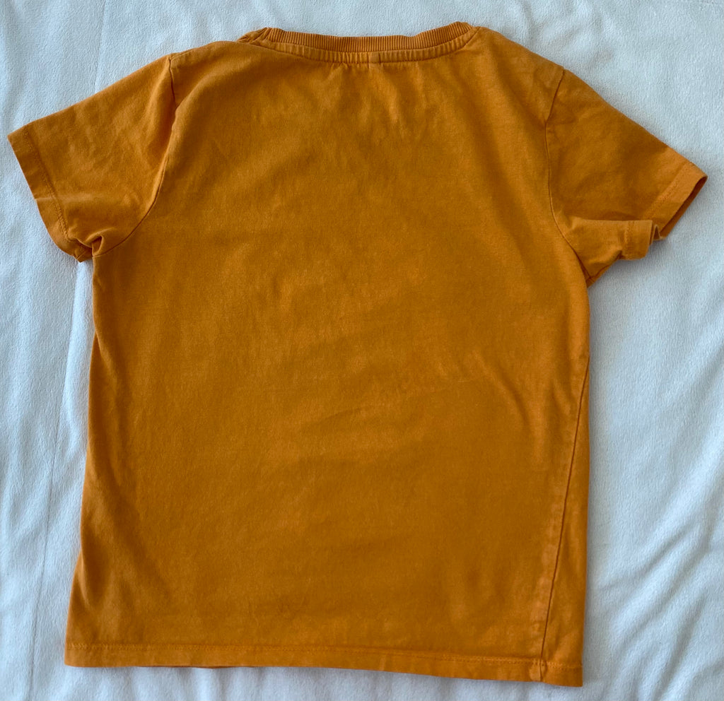 Rückansicht eines orangefarbenen Kinder T-Shirts von NAME IT Größe 134–140 ohne Print, flach liegend auf hellem Hintergrund