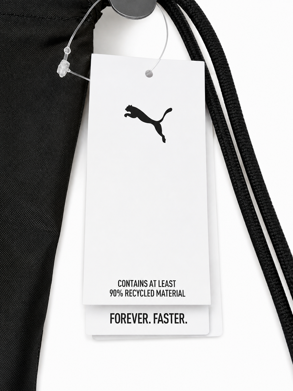 Detailaufnahme eines schwarzen PUMA Gym Sacks mit Fußball-Motiv, grünem PUMA Logo und großem weißen PUMA Schriftzug Etikett