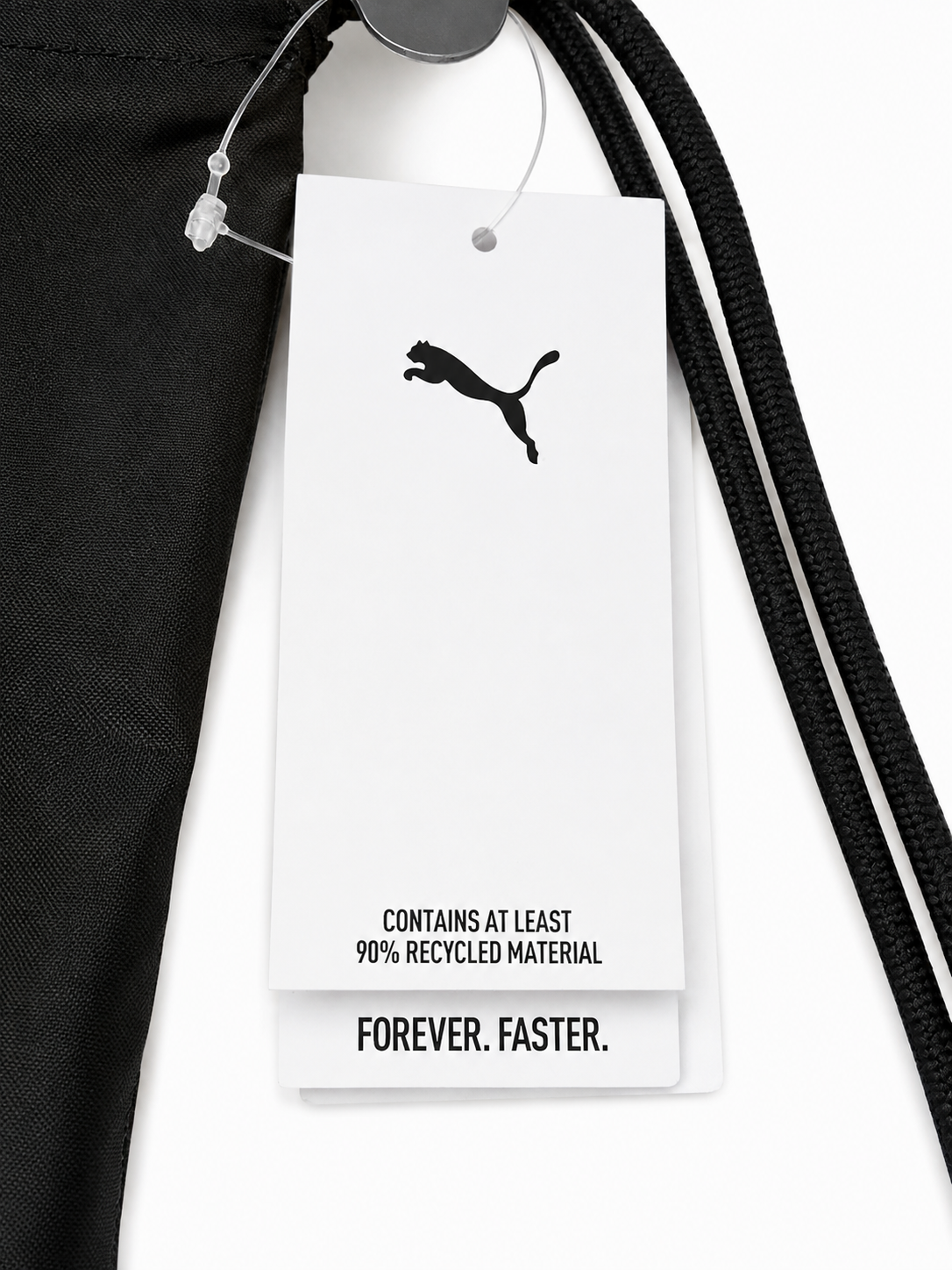 Detailaufnahme eines schwarzen PUMA Gym Sacks mit Fußball-Motiv, grünem PUMA Logo und großem weißen PUMA Schriftzug Etikett
