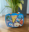 Pokémon Snackbox mit Pikachu, Schiggy, Glumanda, Bisasam, Mauzi und Plinfa auf Holztisch fotografiert