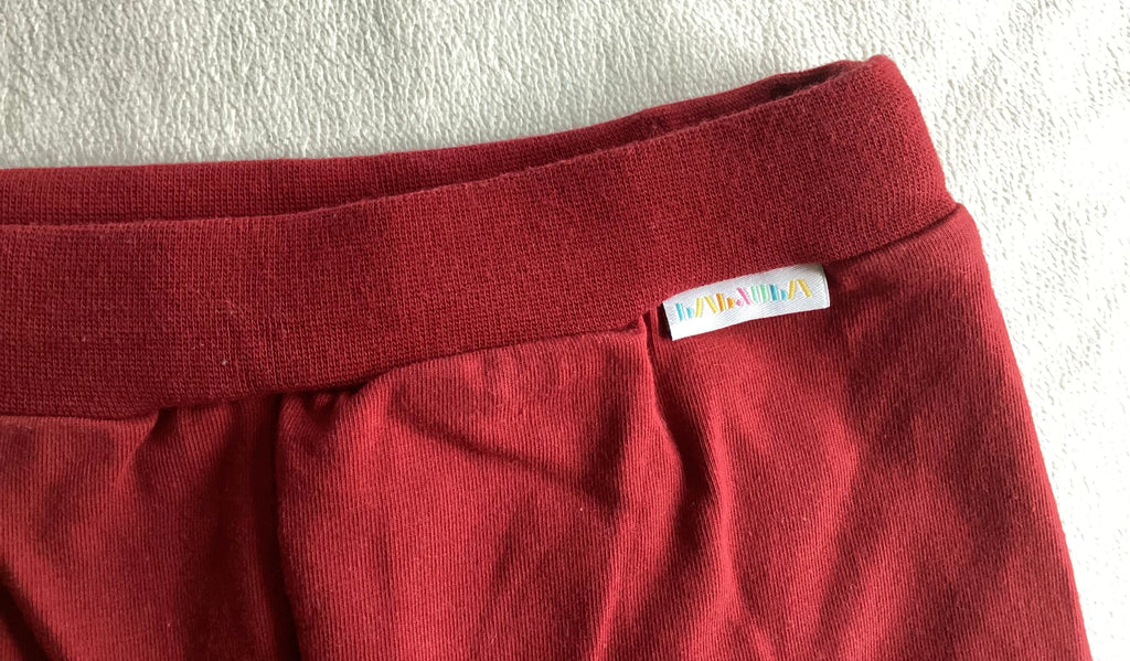 BABAUBA Kinder Shorts Rot Detailaufnahme mit Logo-Label am Bund