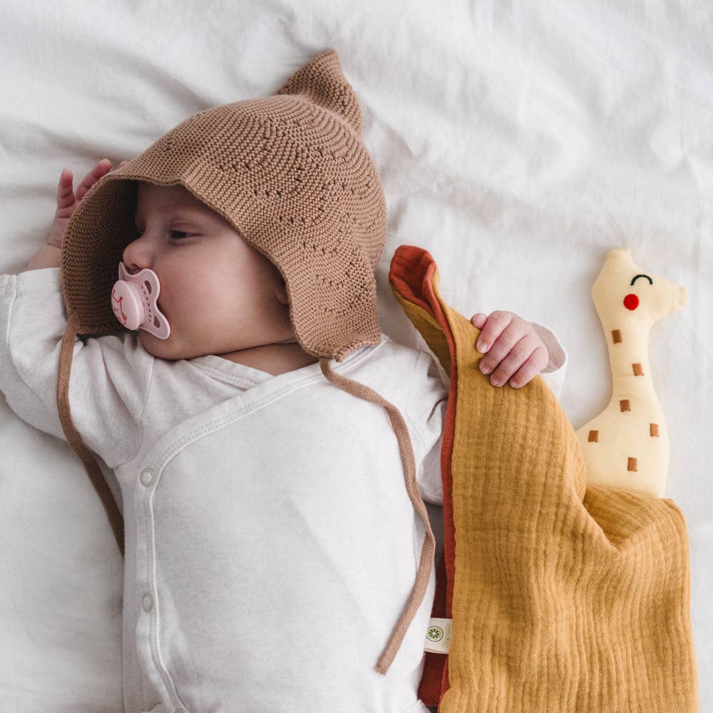 Baby mit Giraffe Schmusetuch im Bett – kuscheliges Schnuffeltuch aus Bio Baumwolle