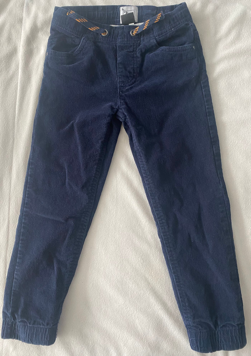 Kinder Cordhose blau mit elastischem Bund und dekorativer Kordel, Vorderansicht mit Taschen und Cordstruktur